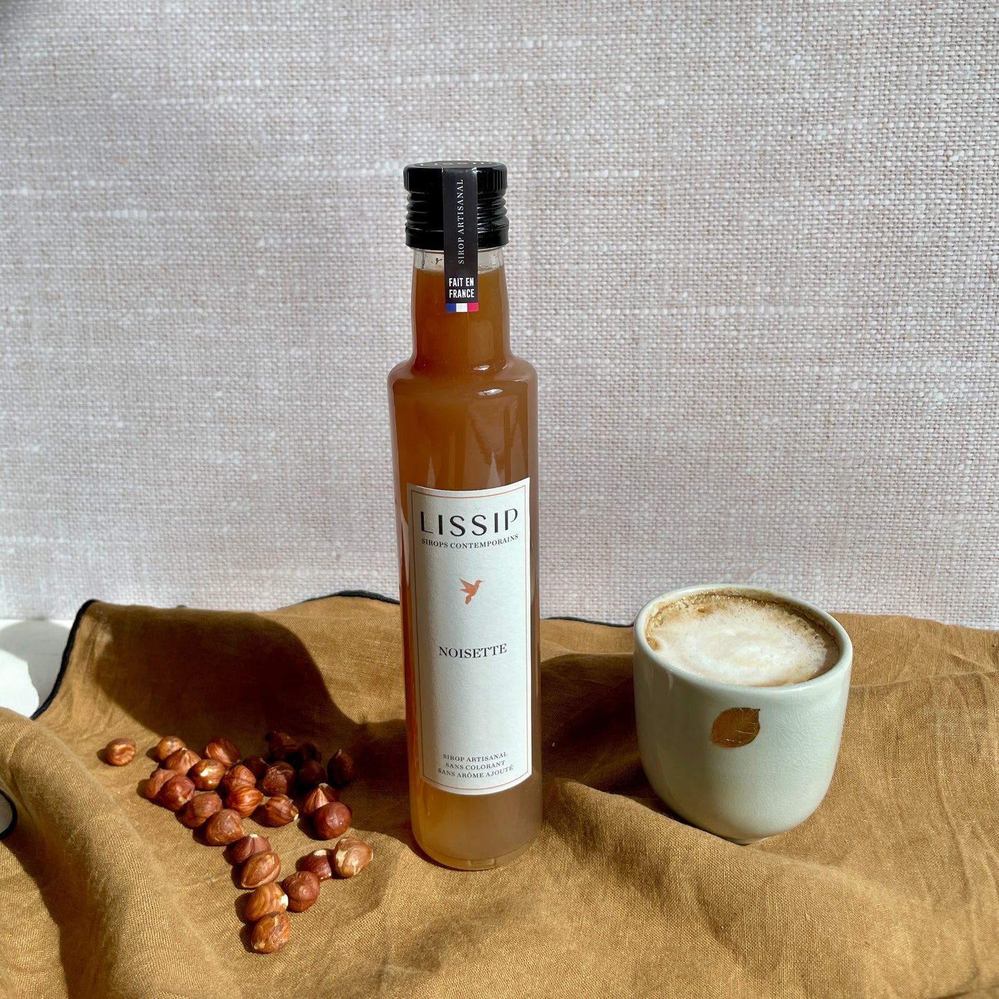 sirop de noisette lissip vu de face avec noisettes et tasse café